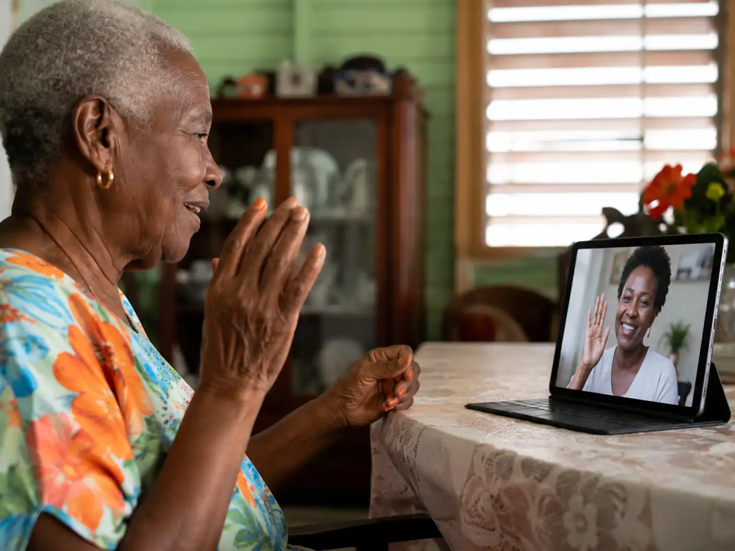 Older Jamaican parent at home on a video call with family overseas