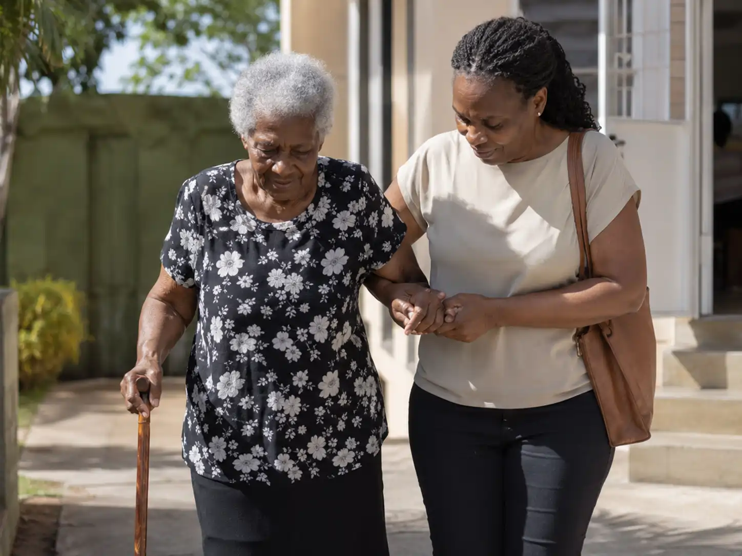 Older Jamaican woman arriving at a clinic with a trusted companion
